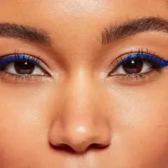 Ein auffälliges Augen Make-up mit leuchtend blauem Eyeliner, der die dunklen Augen betont.