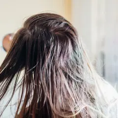 Nasse Haare, die nur mit Wasser gewaschen werden. Eine Hand streicht durch die feuchten Strähnen, die leicht glänzen.