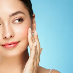 Sanfte Berührung auf rosiger Haut, die von Retinol und Niacinamid profitiert.