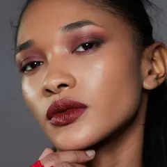 Ein dramatisches Abend Make-up mit tiefroten Lippen und rauchigen, burgunderfarbenen Lidschatten.