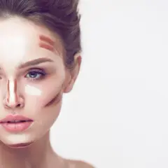 Frauenkopf mit Konturen und hellem Concealer auftragen, bereit zum Verblenden für einen perfekten Look.