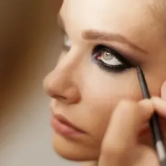Ein Make-up-Artist kreiert dramatische smokey eyes mit einem Kajalstift.