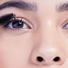 Eine Mascara-Bürste betont die Wimpern, um die schönen, runden Augen hervorzuheben.