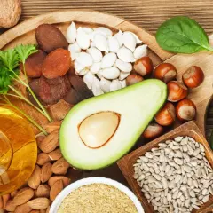 Reichhaltige Lebensmittel für gesunde **Vitamin E Haut**: Nüsse, Samen, Avocado, Öl, Trockenfrüchte und grünes Gemüse.