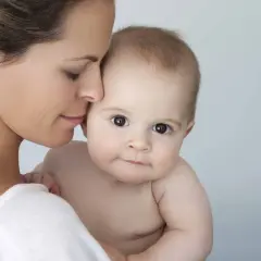 Mutter hält ihr Baby. Hautpflege mit Niacinamid ist auch in der Schwangerschaft sicher und gut für die Haut.