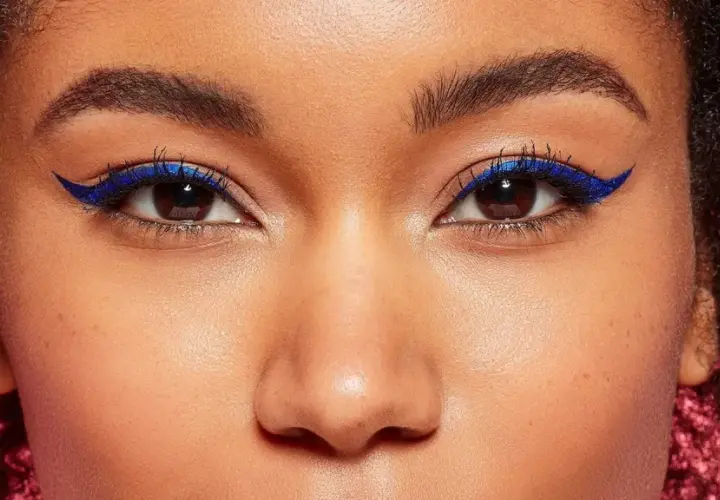 Ein auffälliges Augen Make-up mit leuchtend blauem Eyeliner, der die dunklen Augen betont.