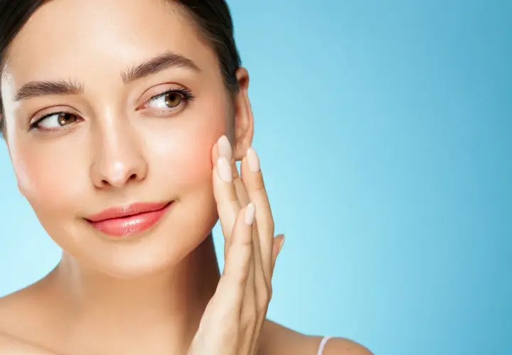 Sanfte Berührung auf rosiger Haut, die von Retinol und Niacinamid profitiert.