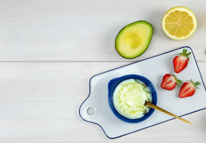 Zutaten für eine natürliche Haarkur: Avocado, Zitrone, Erdbeeren, Honig und Mandeln.