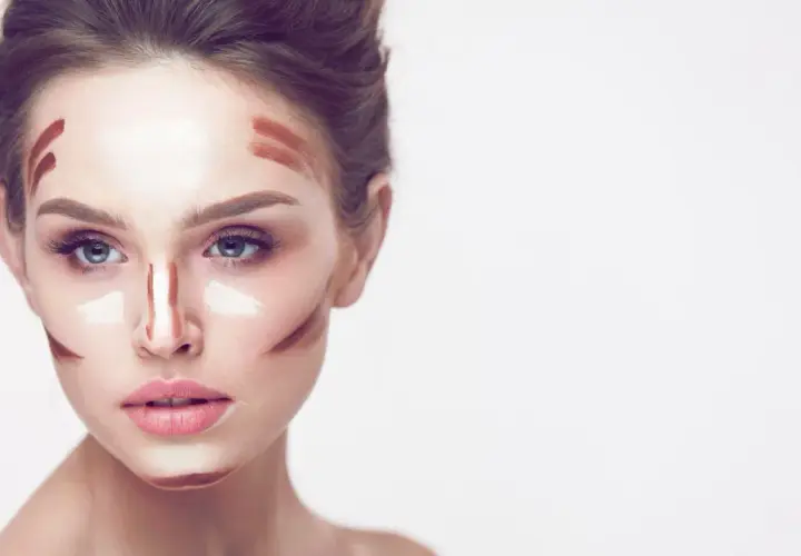 Frauenkopf mit Konturen und hellem Concealer auftragen, bereit zum Verblenden für einen perfekten Look.