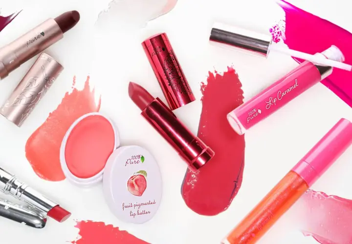 Verschiedene Lippenstifte und Lipglosse in Rottönen und Pink. Die Produkte bestehen aus natürlichen Inhaltsstoffen, wie Fruchtpigmenten.