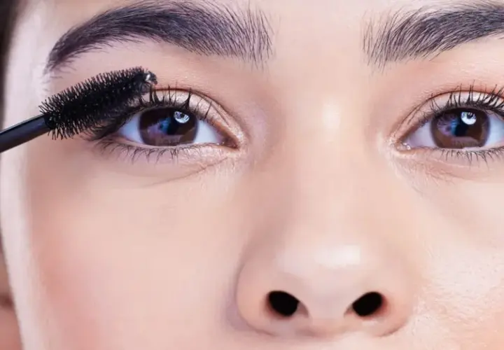 Eine Mascara-Bürste betont die Wimpern, um die schönen, runden Augen hervorzuheben.