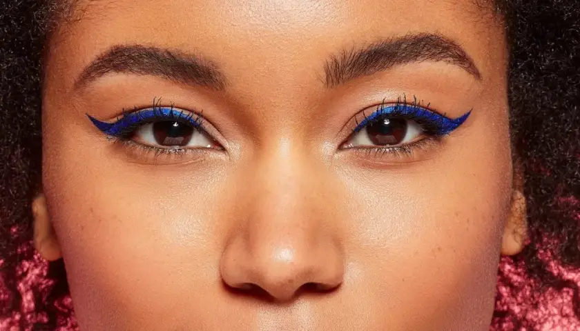 Ein auffälliges Augen Make-up mit leuchtend blauem Eyeliner, der die dunklen Augen betont.