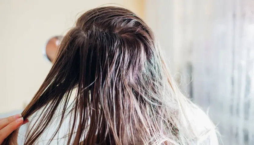Nasse Haare, die nur mit Wasser gewaschen werden. Eine Hand streicht durch die feuchten Strähnen, die leicht glänzen.