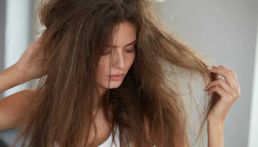 Frau mit strohigen, trockenen Haaren, die sich fragt, ob trockene Haare Ursache Hormone sein könnten.