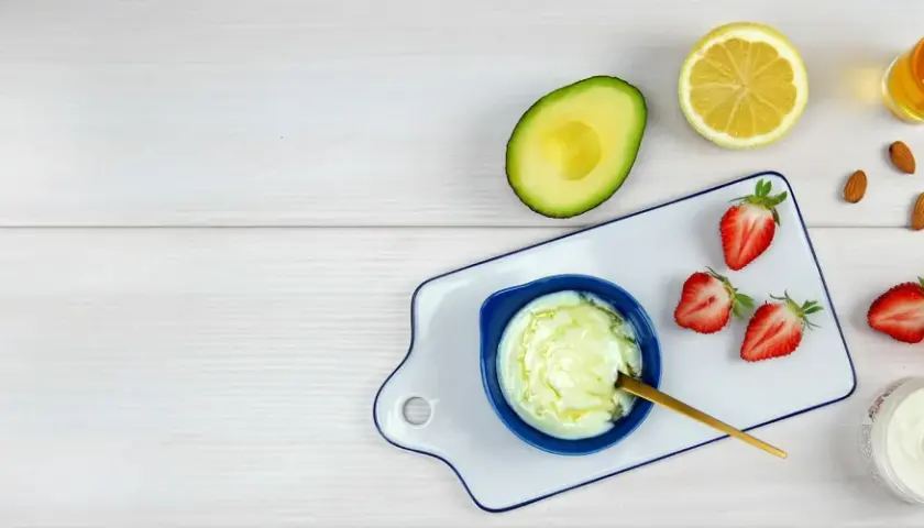 Zutaten für eine natürliche Haarkur: Avocado, Zitrone, Erdbeeren, Honig und Mandeln.