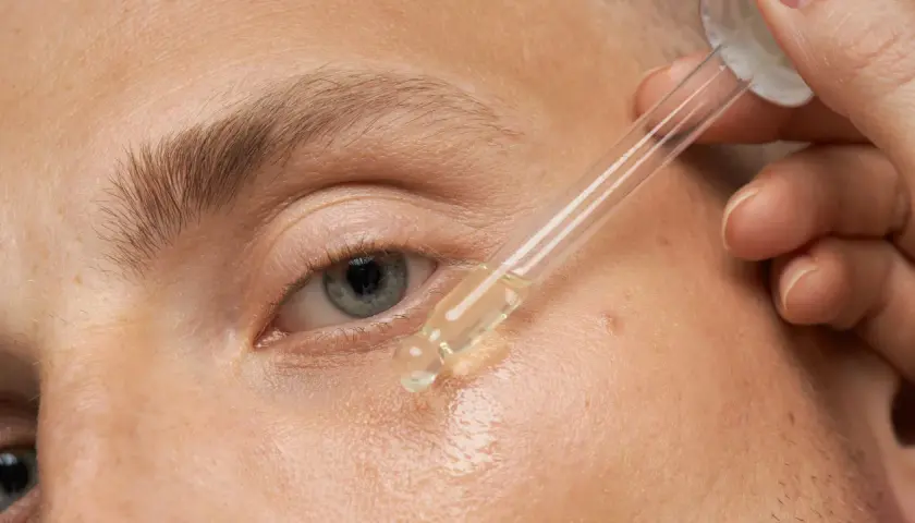 Ein Tropfen Serum wird auf die Haut aufgetragen. Dies ist eine Methode, was hilft gegen trockene Haut und spendet Feuchtigkeit.