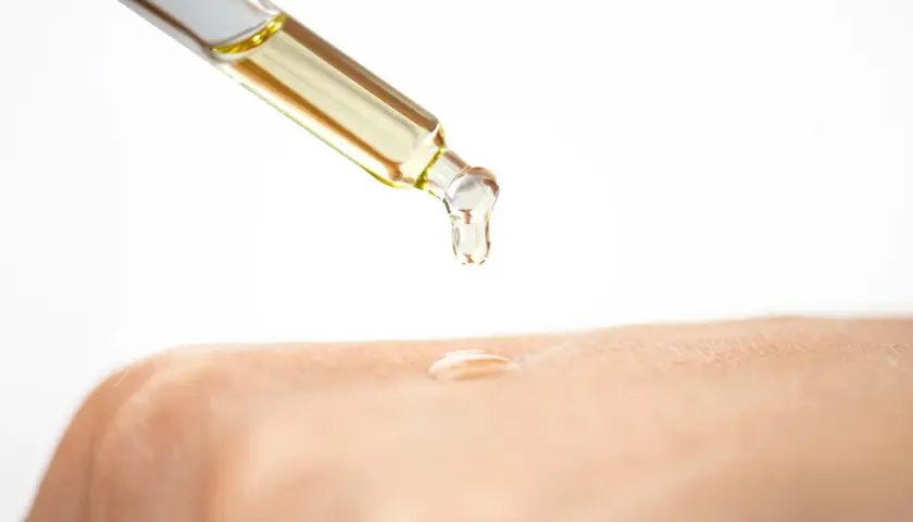 Ein Tropfen Öl mit Glycerin fällt auf die Haut.