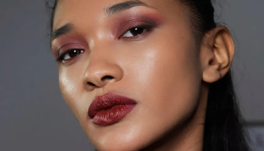 Ein dramatisches Abend Make-up mit tiefroten Lippen und rauchigen, burgunderfarbenen Lidschatten.