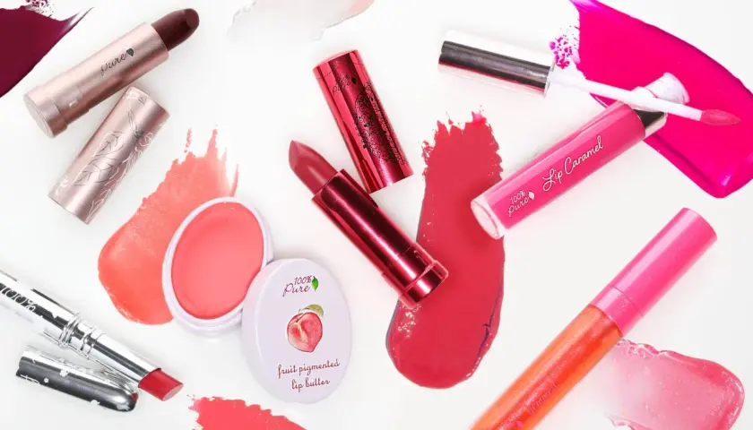 Verschiedene Lippenstifte und Lipglosse in Rottönen und Pink. Die Produkte bestehen aus natürlichen Inhaltsstoffen, wie Fruchtpigmenten.