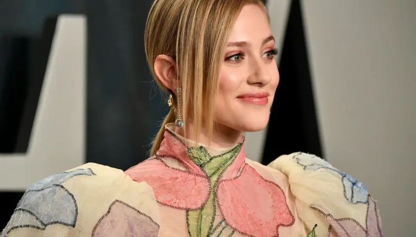 Ein Lächeln in Pfirsich-Nude-Tönen, das durch ein blumenverziertes Kleid und funkelnde Ohrringe unterstrichen wird.