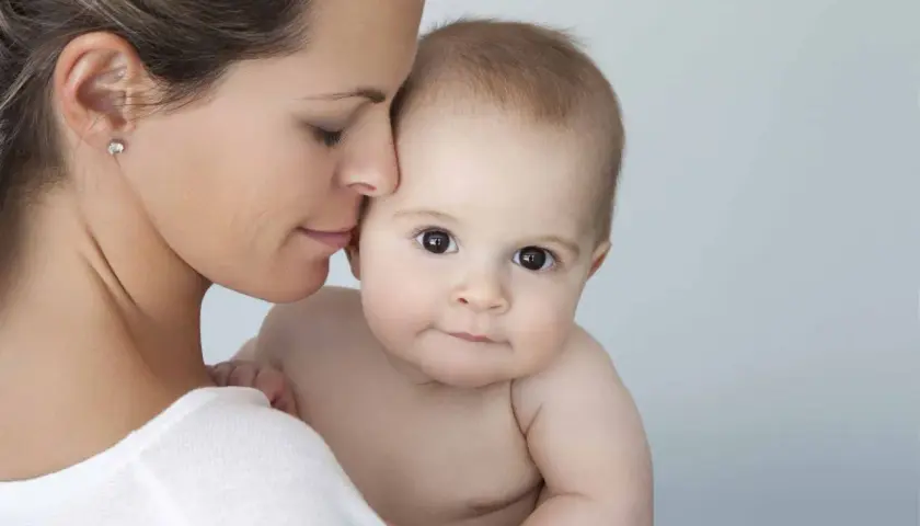 Mutter hält ihr Baby. Hautpflege mit Niacinamid ist auch in der Schwangerschaft sicher und gut für die Haut.