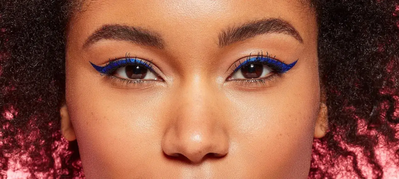 Ein auffälliges Augen Make-up mit leuchtend blauem Eyeliner, der die dunklen Augen betont.