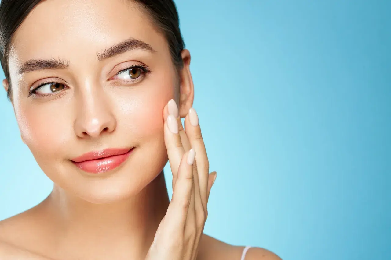 Sanfte Berührung auf rosiger Haut, die von Retinol und Niacinamid profitiert.