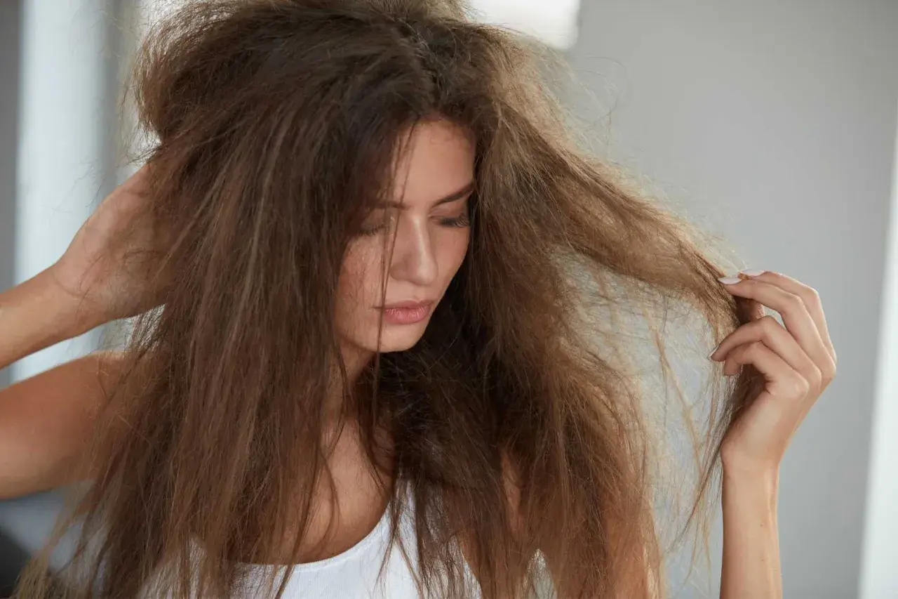 Frau mit strohigen, trockenen Haaren, die sich fragt, ob trockene Haare Ursache Hormone sein könnten.