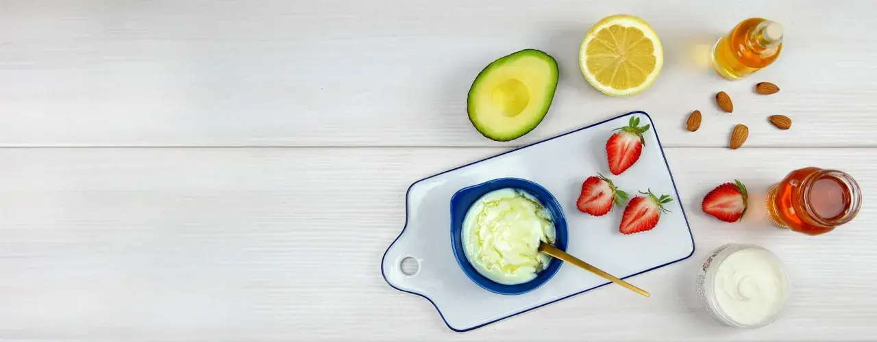 Zutaten für eine natürliche Haarkur: Avocado, Zitrone, Erdbeeren, Honig und Mandeln.