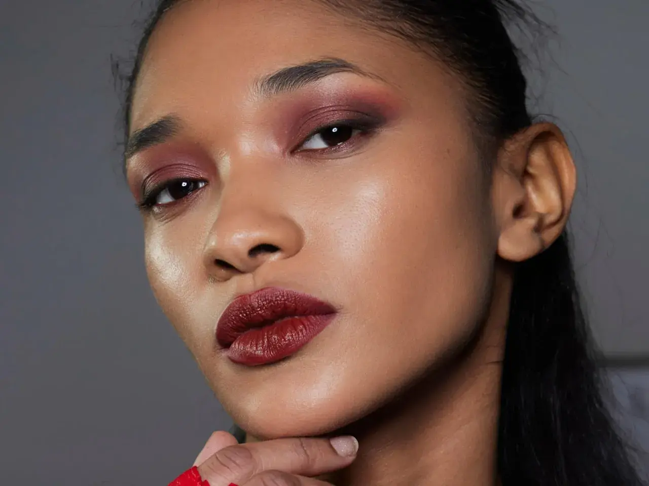 Ein dramatisches Abend Make-up mit tiefroten Lippen und rauchigen, burgunderfarbenen Lidschatten.