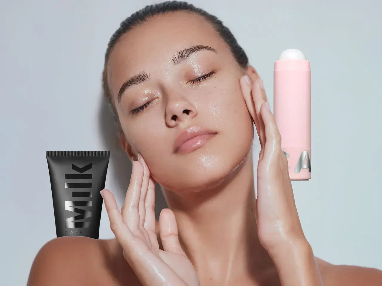 Ein Model mit geschlossenen Augen und feuchter Haut, umgeben von Milk Make-up Produkten. Was ist ein Primer? Er bereitet die Haut auf Make-up vor.