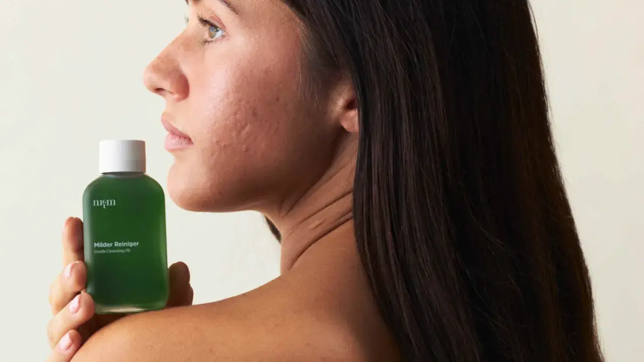 Sanfte Pflege für empfindliche Haut: Eine Frau hält eine Flasche mit mildem Reiniger.