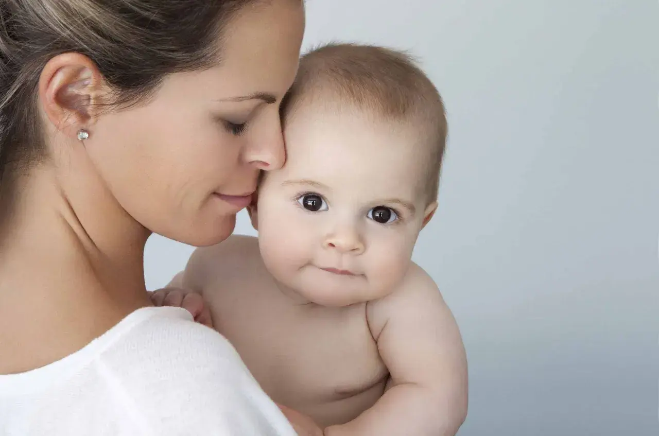 Mutter hält ihr Baby. Hautpflege mit Niacinamid ist auch in der Schwangerschaft sicher und gut für die Haut.