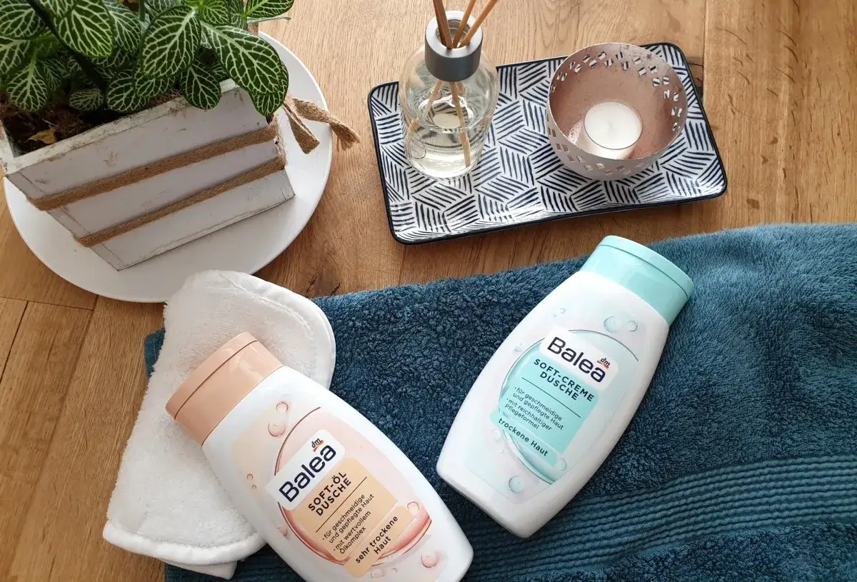 Balea Soft-Öl Dusche und Soft-Creme Dusche für sehr trockene Haut, neben einem Handtuch und Deko.