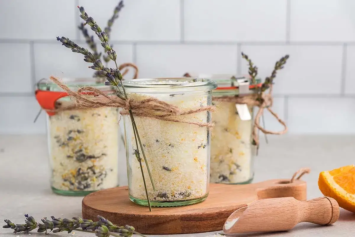Selbstgemachtes Badesalz in Gläsern, verziert mit Lavendel und Orangenschale. Perfekt zum Entspannen.