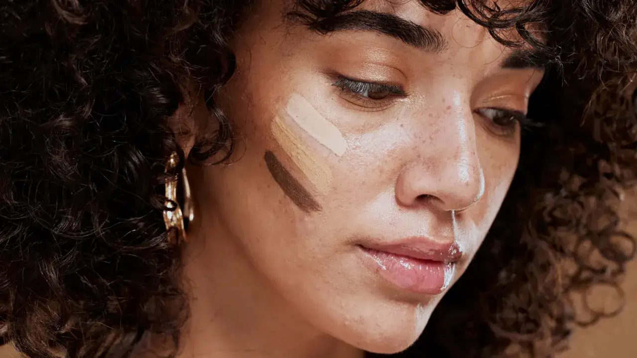 Frauenhaut mit Streifen verschiedener Concealer-Töne, um den perfekten Farbton zu finden.